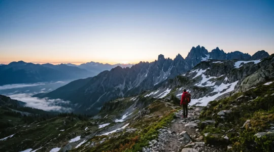 Vue panoramique sur une crete des Alpes francaises au lever du jour, illustrant le choix d'une destination montagnarde